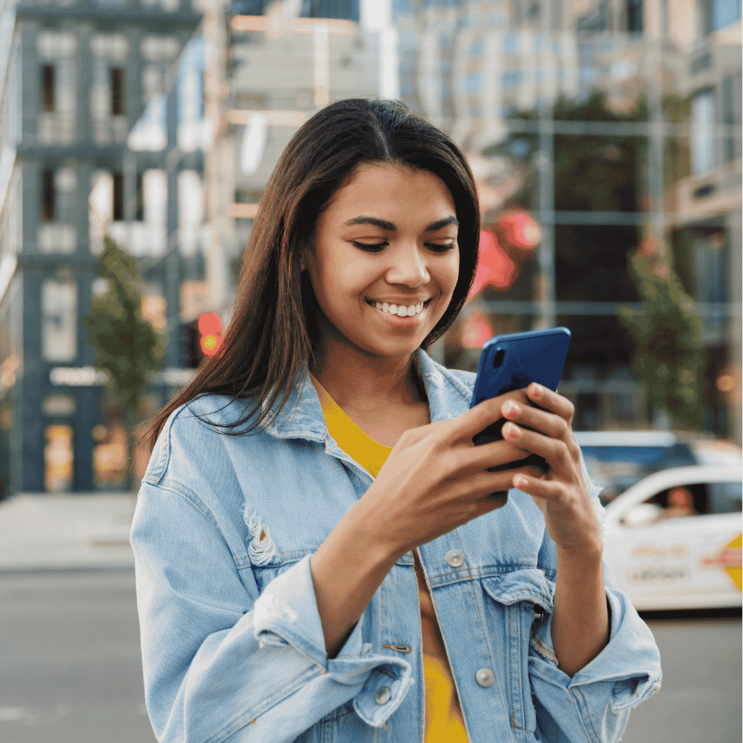 Woman smiling on her phone in the city