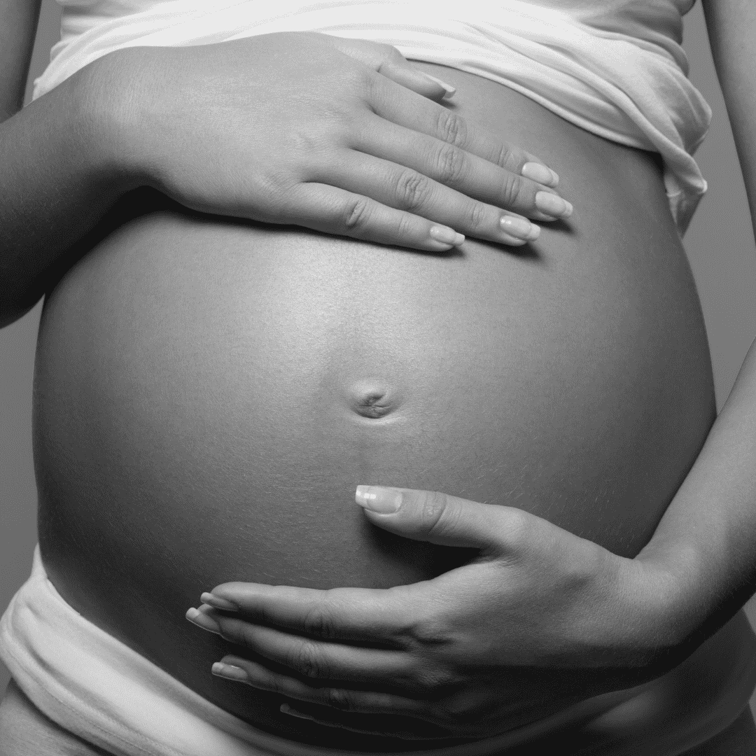 Black and white photo of belly with hands